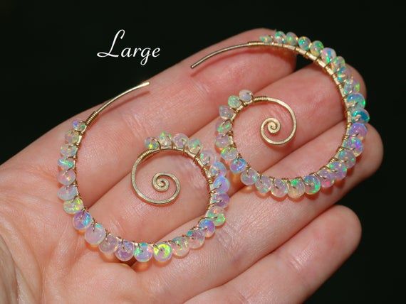 THE JEWELRY IS SHIPPED via DHL EXPRESS (2-5 days delivery door to door). THE DHL SHIPPING COST IS INCLUDED IN THE PRICE.The Sea Shell Earrings - Ethiopian Opal Wire Wrapped Spiral Hoop Earrings, Genuine Welo Opal EarringsThe earrings come with silicone earring backs.► Measurements / Details:- Length of the spiral hoops including Opals: Small - 1.25" (~3.2 cm); Large - 1.5" (~3.7 cm)- Gold: High quality Gold Filled- Silver: High quality Sterling Silver- The earrings come with silicone earring bac Crystal Wraps, Ethiopian Opal Earrings, Sea Shell Earrings, Fire Opal Earrings, Spiral Earrings, Hammered Gold, Handmade Wire Jewelry, Gold Filled Earrings, Wing Earrings