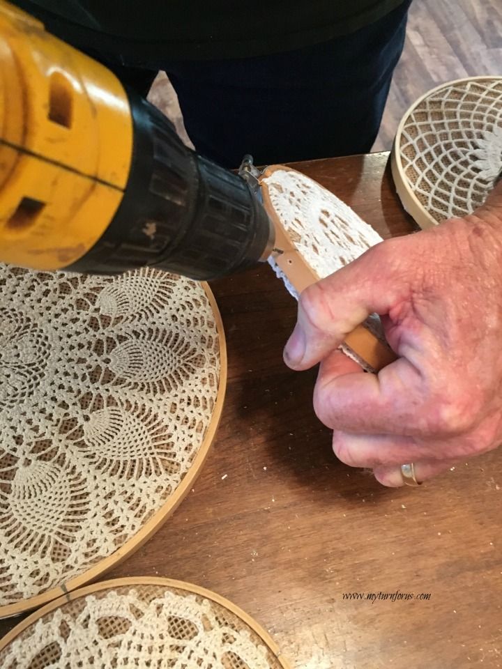 a person is using a drill to cut lace on doily with a small machine