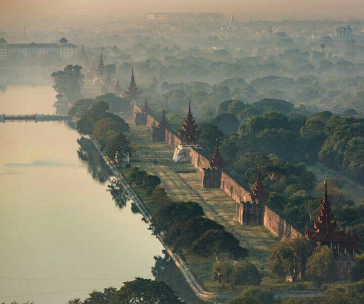 an aerial view of a city with lots of trees and buildings on the other side