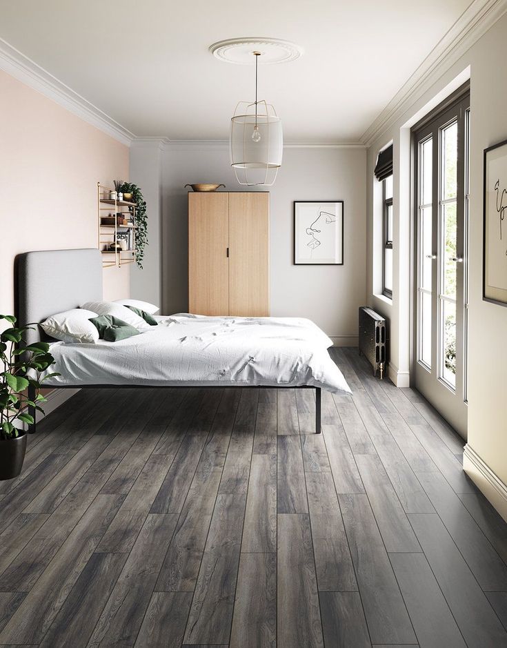 a bedroom with wood flooring and white walls