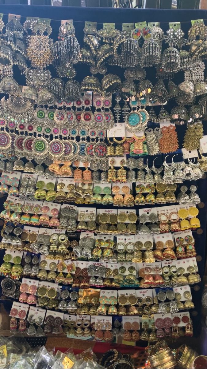 a display case filled with lots of different types of earrings and necklaces on top of each other