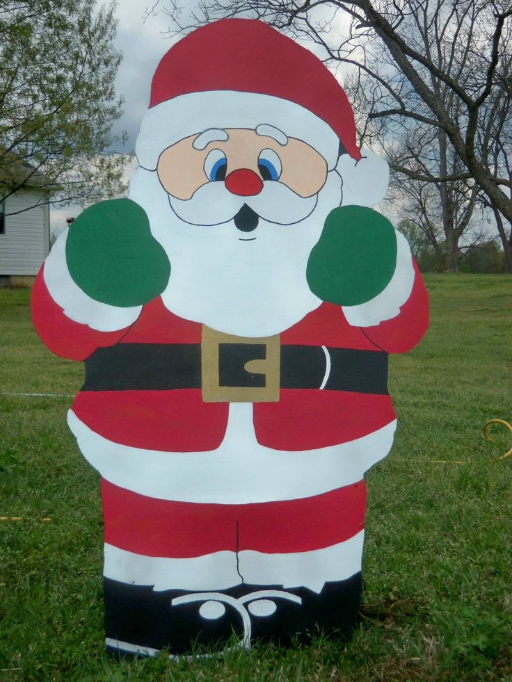 an inflatable santa clause standing on the grass