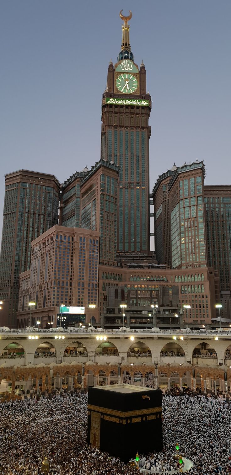 a large group of people standing in front of a building with a clock on it