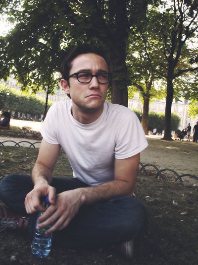 a man sitting on the ground holding a water bottle