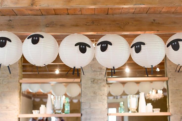 white paper lanterns with black eyes are hanging from the ceiling