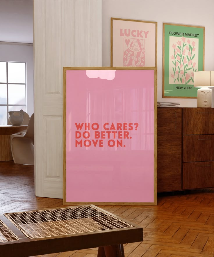 a pink poster sitting on top of a hard wood floor next to a wooden table