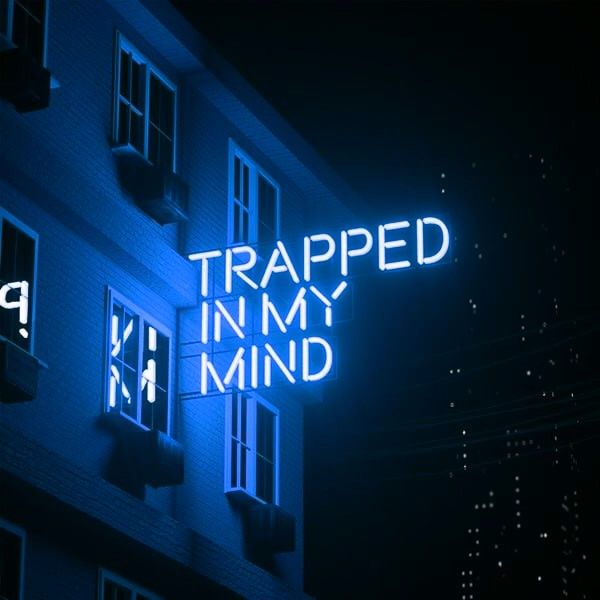 a neon sign that reads trapped in my mind on the side of a building at night