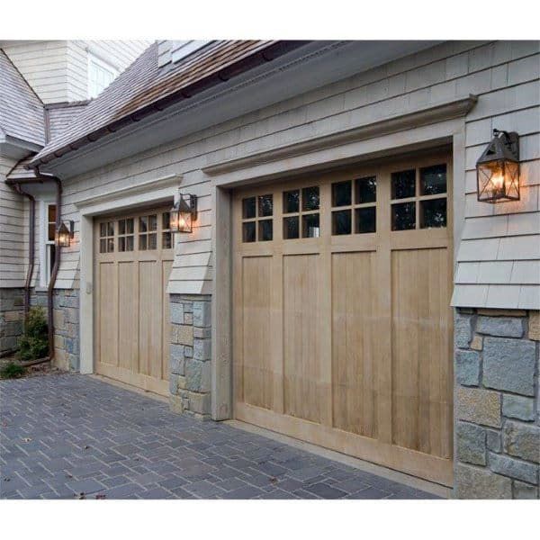 two garage doors on the side of a house next to a brick walkway and driveway