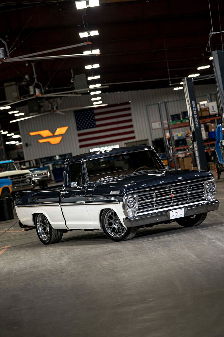 an old black and white truck parked in a garage