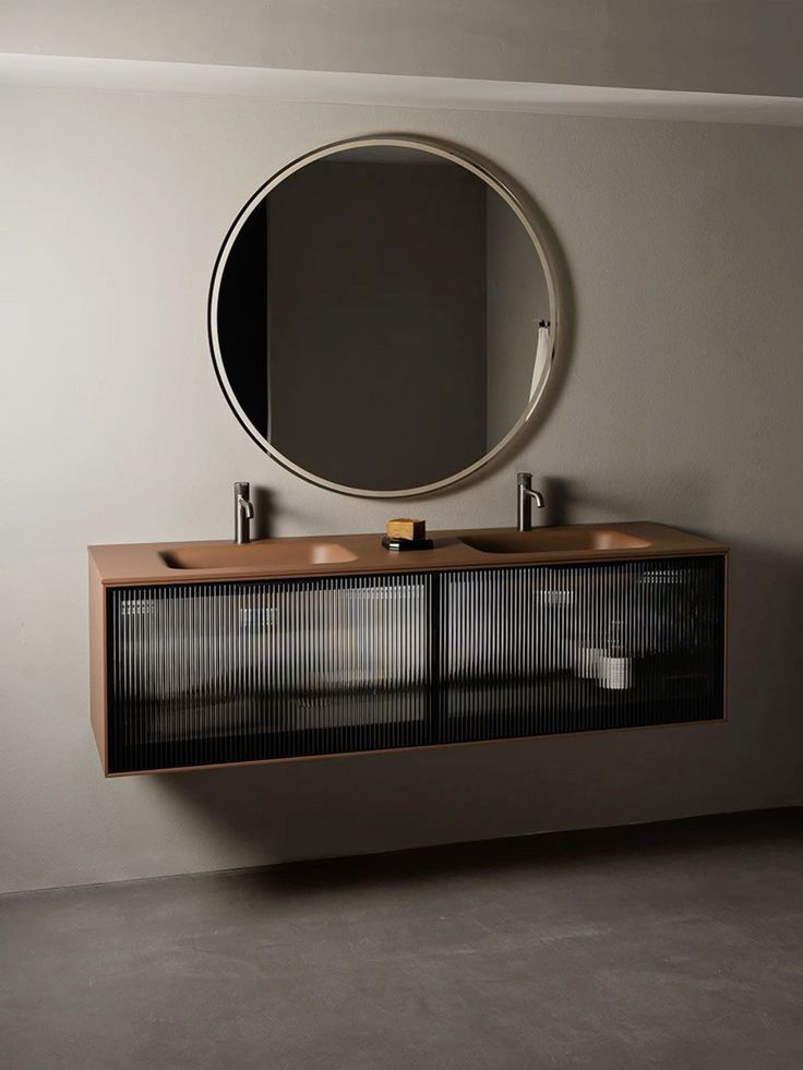 a bathroom vanity with a round mirror above it