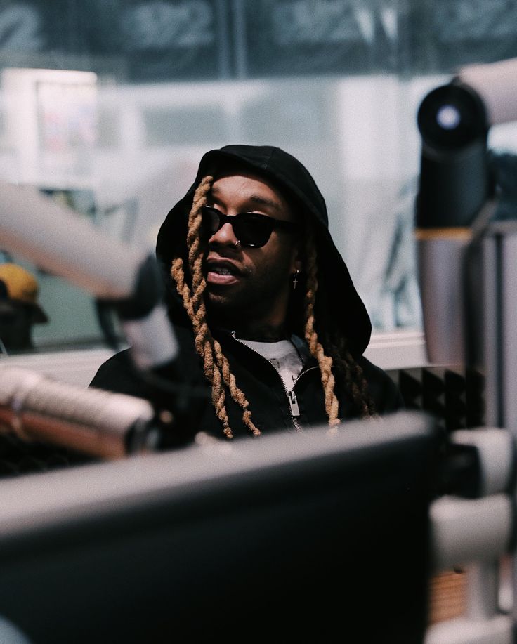 a man with dreadlocks sitting in front of a computer