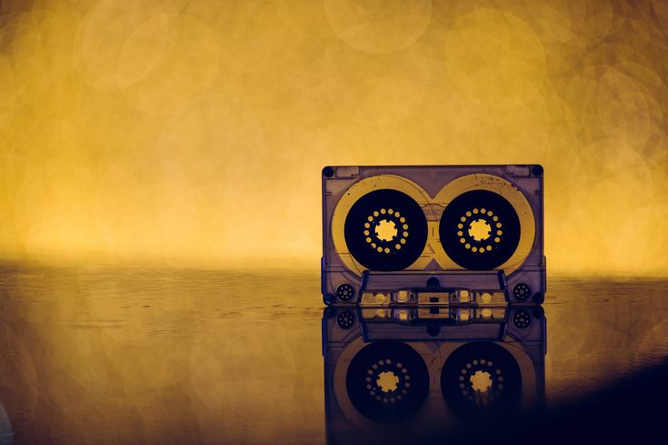 an old fashioned radio sitting on top of a table next to a yellow light in the background