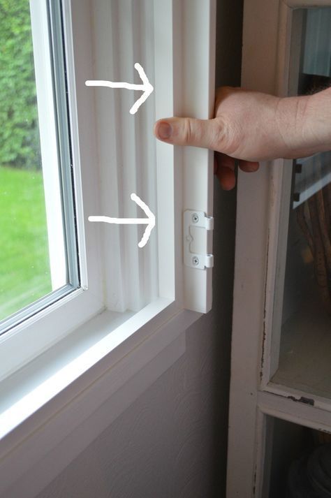 a hand is pointing at an open window with white arrows on the outside and right side