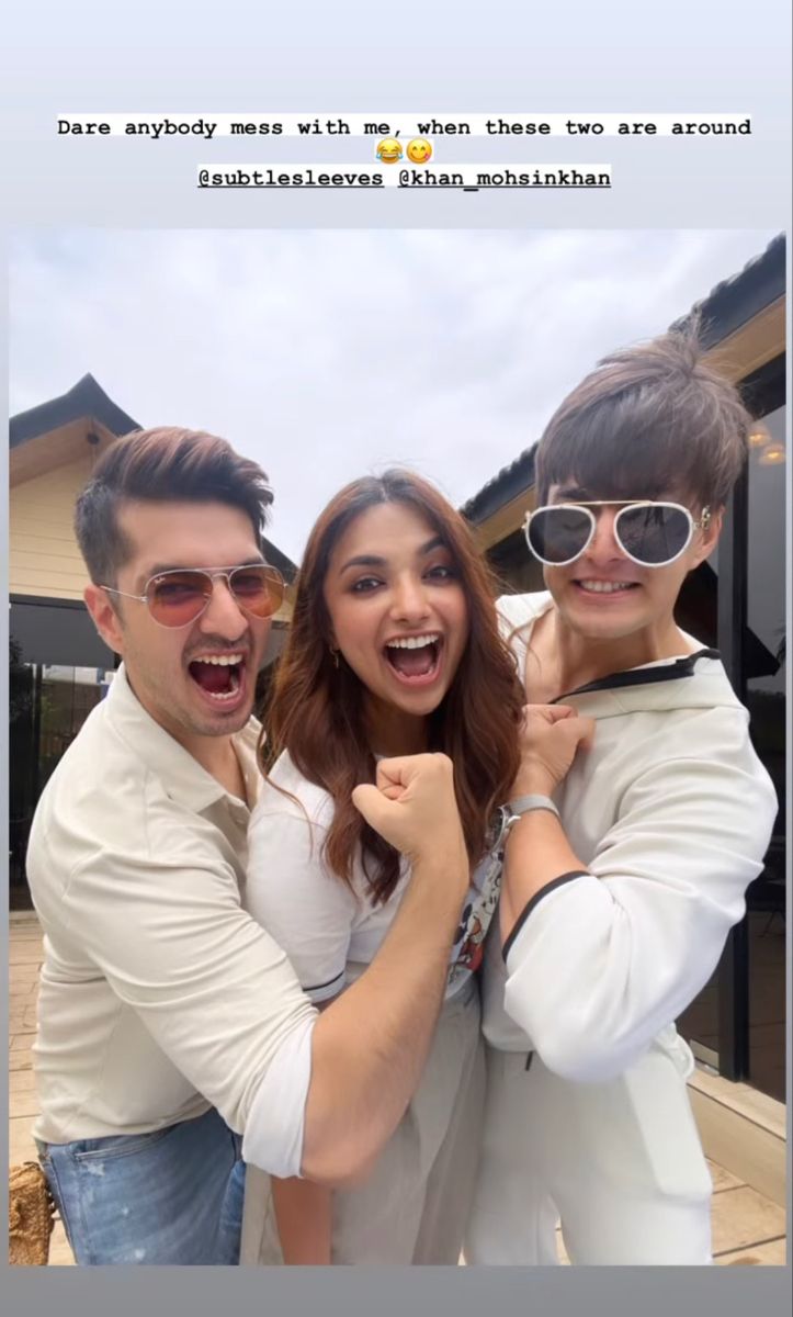 two men and a woman are posing for a photo with their arms around each other