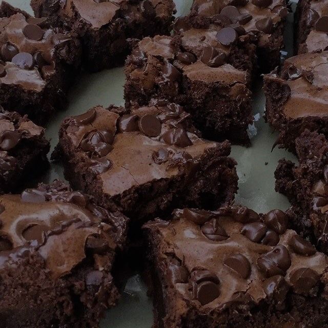 there are chocolate brownies on the table ready to be cut into pieces and eaten