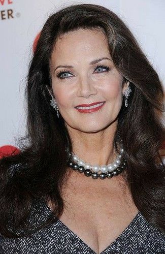 a woman with long dark hair wearing a pearl necklace and pearls on her neck smiling