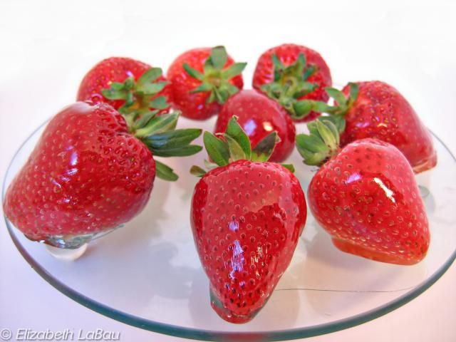 strawberries are arranged on a glass plate