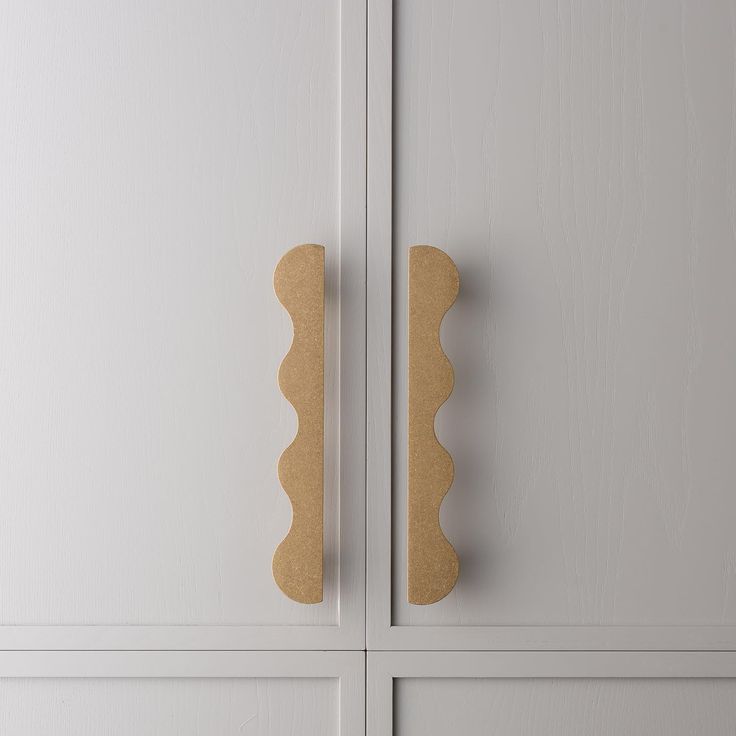 a close up of a door handle on a white cabinet