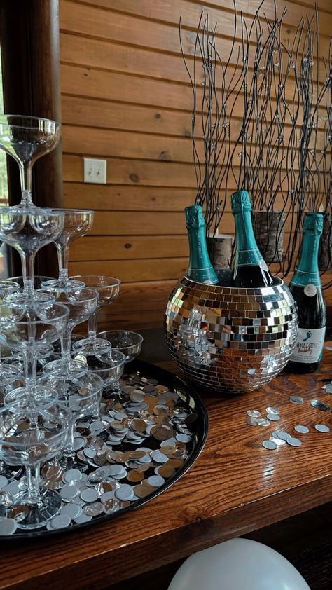 there are many wine glasses and bottles on the table with confetti in them