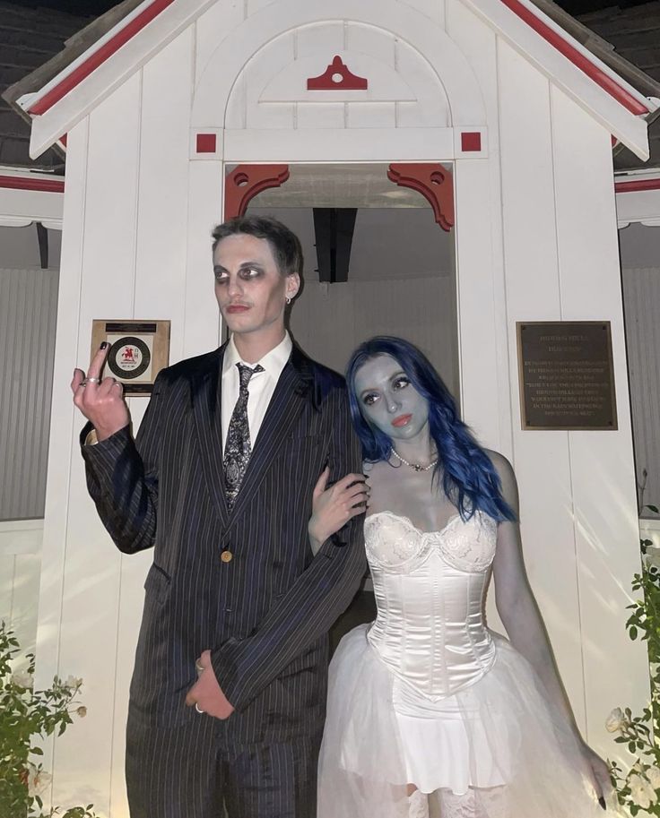 a man and woman dressed up as corpse bride and groom in front of a church