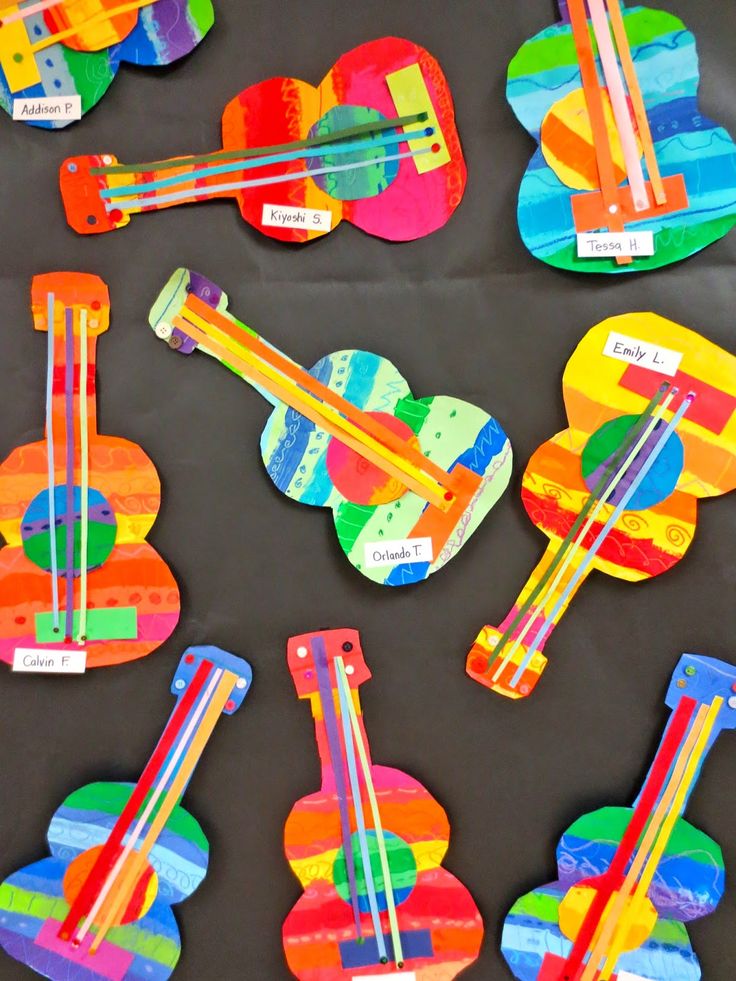 colorful paper crafts are arranged on a table with scissors and other items to make them look like guitars