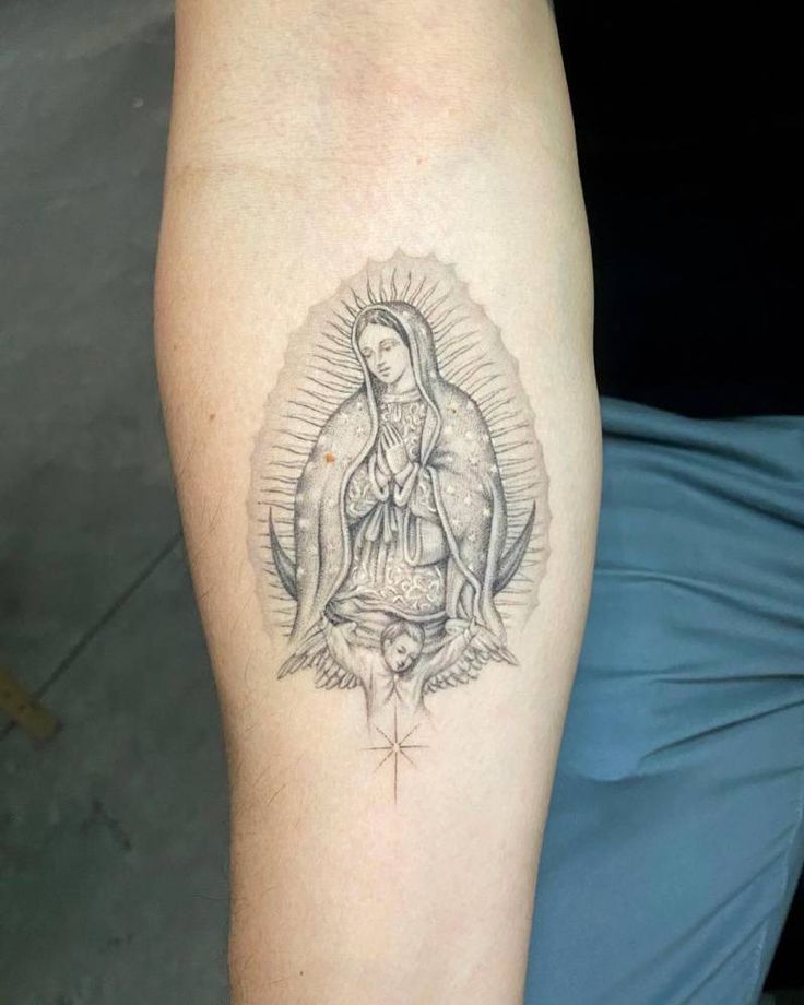 a woman's leg with a tattoo on it that has an image of the virgin mary