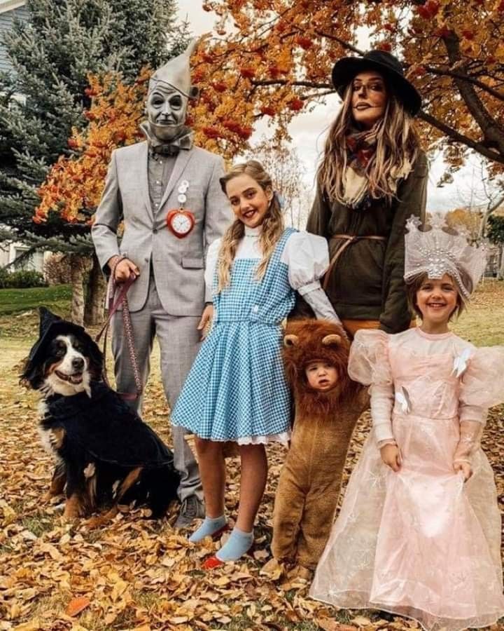 a group of people in costumes standing next to each other with a dog on a leash