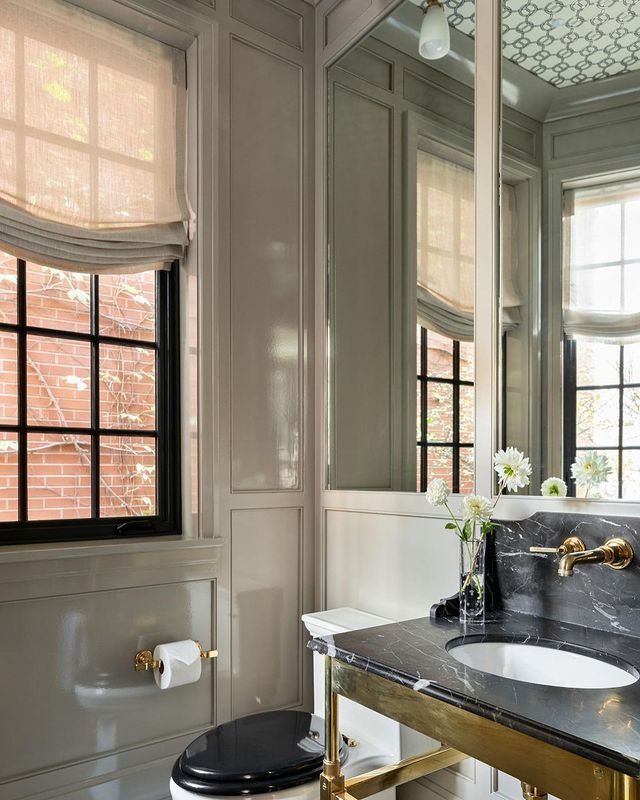 a black and white bathroom with gold fixtures