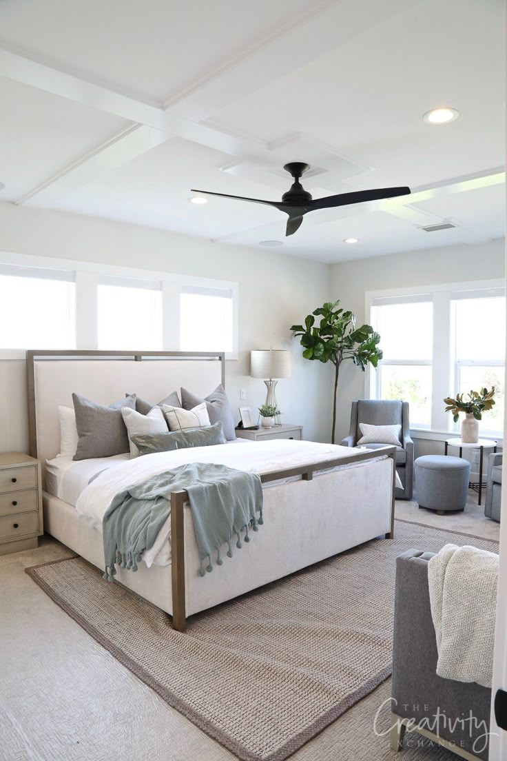 a bedroom with a large bed and ceiling fan