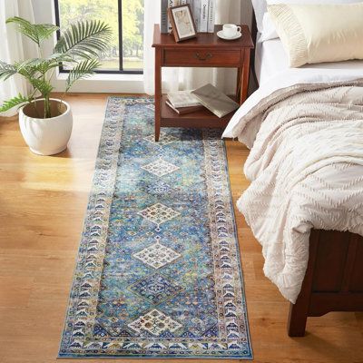 a bed room with a neatly made bed and a large rug on the floor next to it