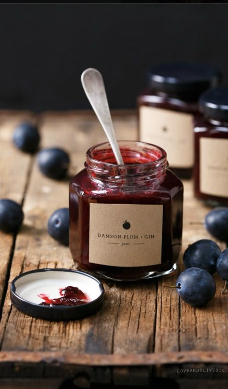 two jars of jam with blueberries next to them