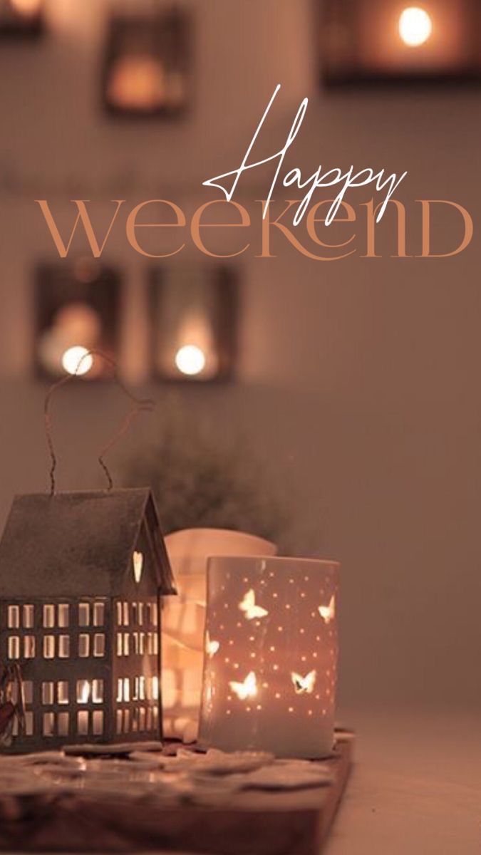 a small house sitting on top of a wooden table next to candles and a card that says happy weekend