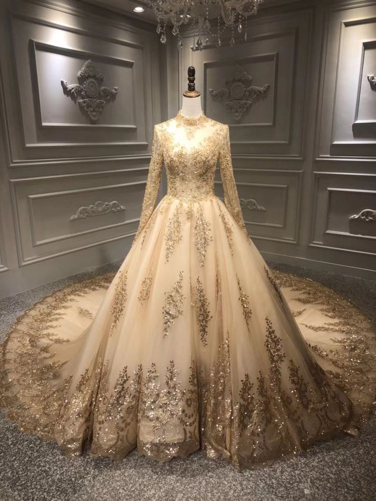 a wedding dress on display in a room with chandelier and wallpapers