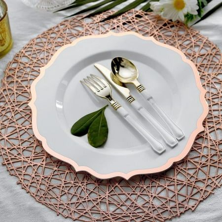 a white plate topped with silverware next to flowers and greenery on top of a table