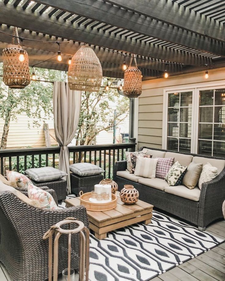 an outdoor living area with wicker furniture and lights