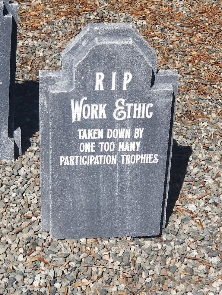 two tombstones sitting in the middle of gravel