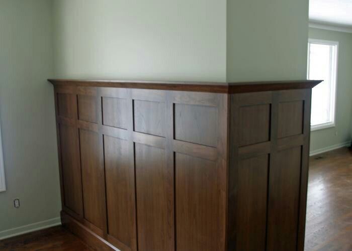 an empty room with wood paneling and hard wood flooring on the far wall