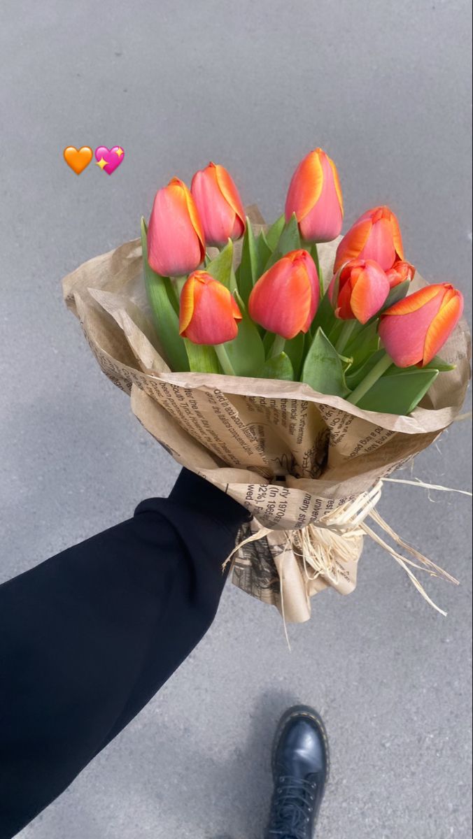 a person is holding a bouquet of tulips