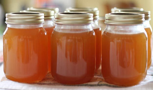 four jars filled with liquid sitting on top of a table