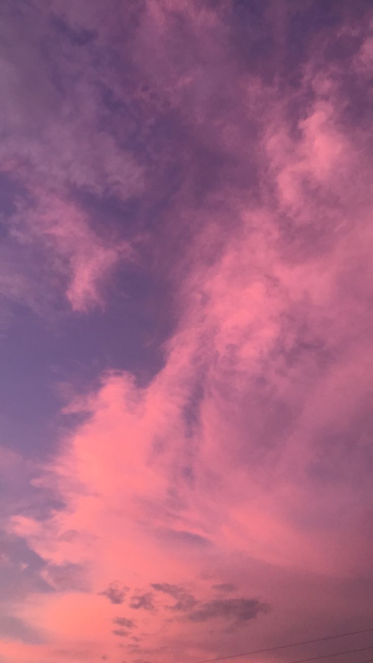 the sky is pink and purple with some clouds