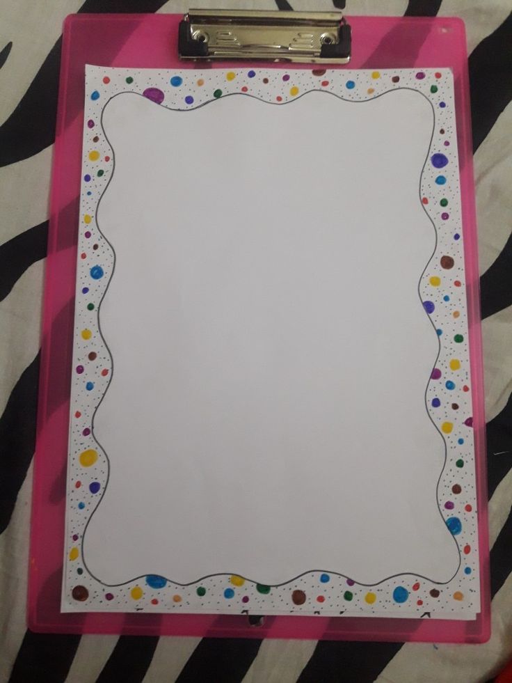 a pink clipboard with white paper and polka dots on it, sitting on a zebra print blanket