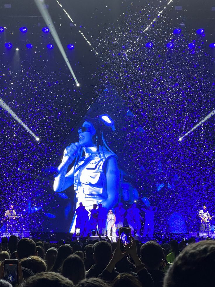 the stage is lit up with blue lights and confetti