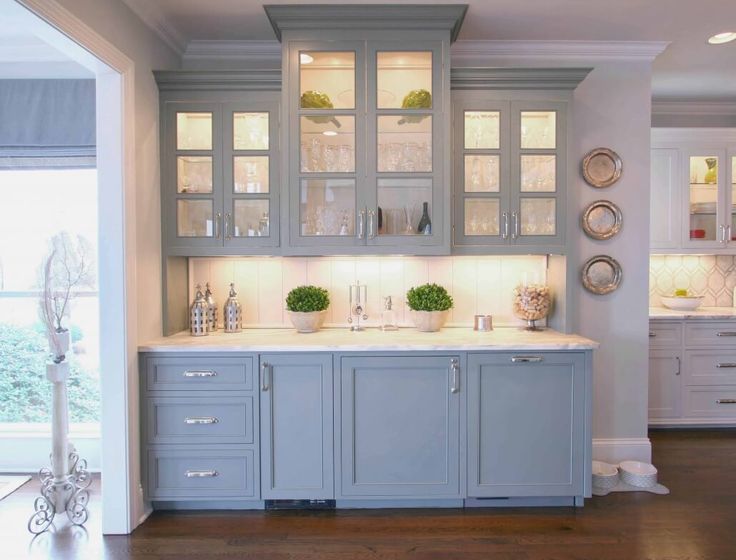 a kitchen with gray cabinets and white counter tops