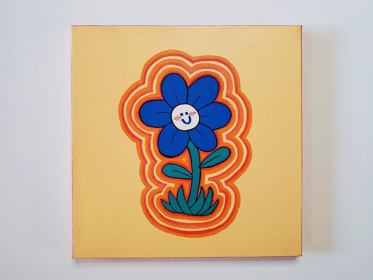 an orange and blue flower with a button in the center on a yellow square canvas