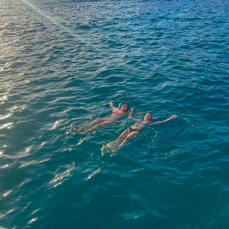 two people are swimming in the ocean together