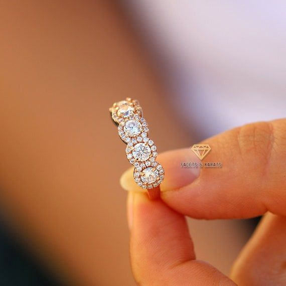 a close up of a person holding a ring with three diamonds on it's side