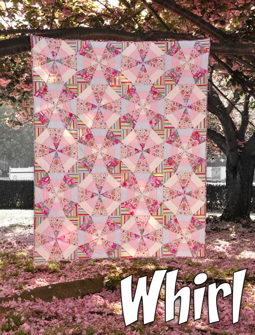 a pink quilt hanging from the side of a tree