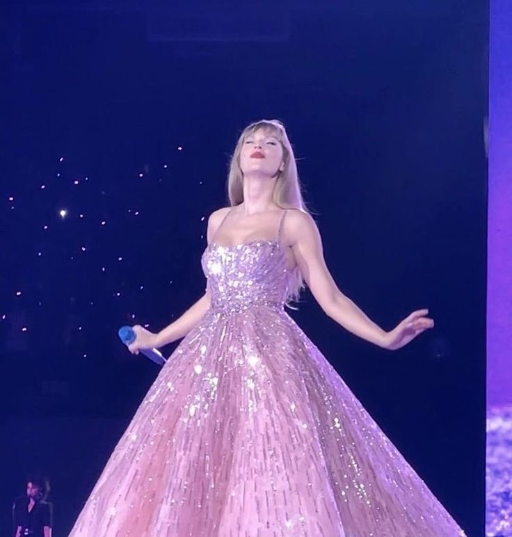 a woman in a pink dress standing on stage