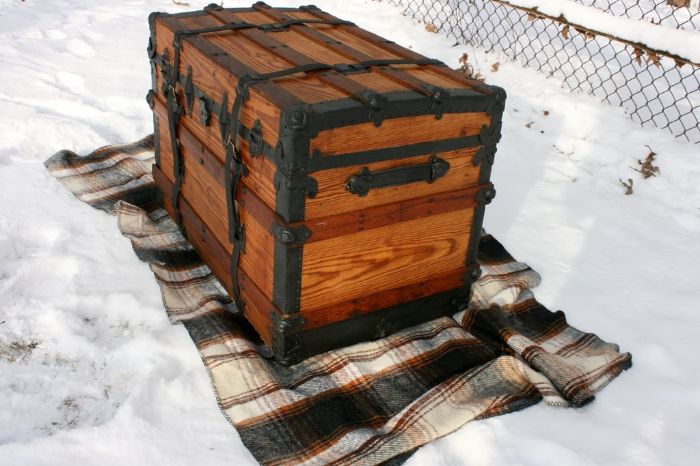 an old trunk sitting on top of a blanket in the snow