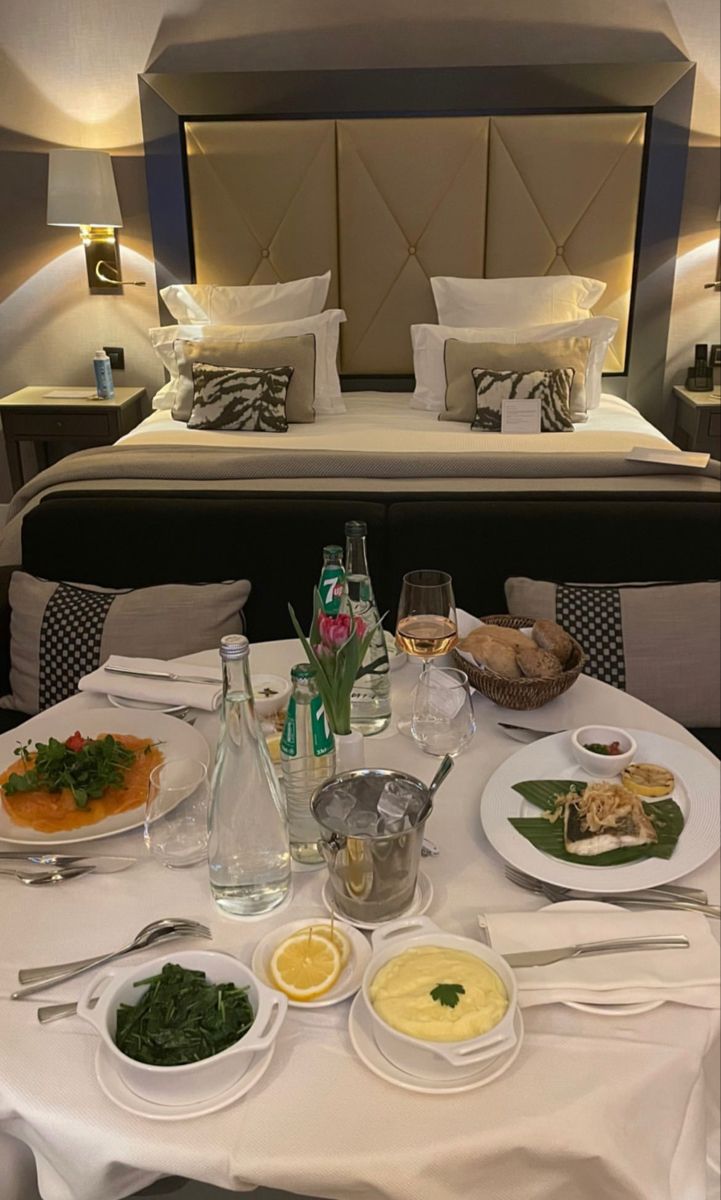 a bed and table with food on it in a room that looks like a hotel